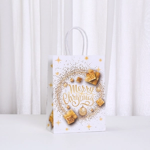 Detail of white Christmas paper gift bag with gold Merry Christmas wreath and ribbon handle