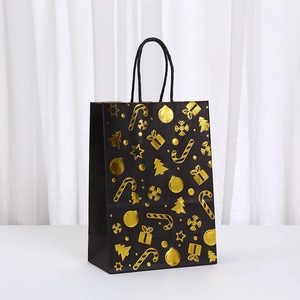 Detailed view of black Christmas gift bag with gold foil festive patterns and rope handles