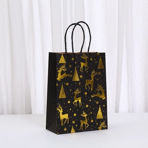 Detail of black gift bag with gold foil reindeer and Christmas tree patterns