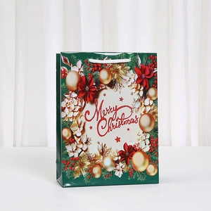 Dark green Merry Christmas paper gift bag with floral wreath and glitter lettering