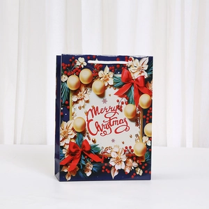 Blue Christmas gift bag with Merry Christmas text and festive floral print motifs