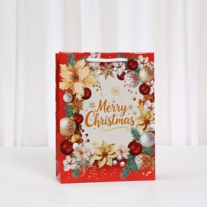 Detail of red Christmas gift bag with golden Merry Christmas text and festive ornaments
