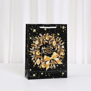 Black Christmas paper gift bag with gold wreath and Merry Christmas greeting