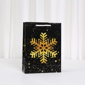Black Christmas gift bag with a large golden sequin snowflake and white handles