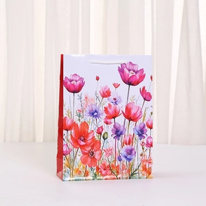 Floral print gift bag with white rope handles and vibrant watercolor flower patterns