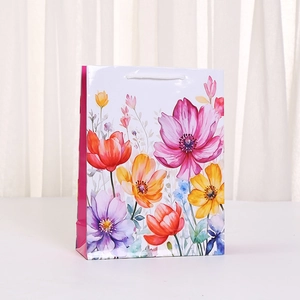 Floral print paper gift bag with colorful flower patterns and white rope handles