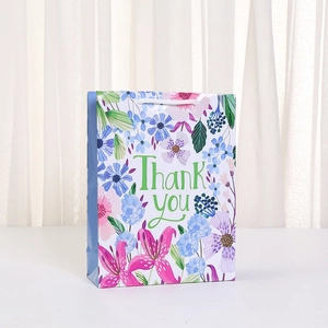 Detail of floral gift bag with Thank You print and sturdy white rope handles for parties