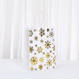 Elegant white paper gift bag with metallic gold snowflake print and white rope handles