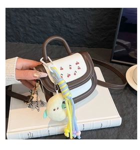 Detail view of mini crossbody bag with cherry print on white PU leather and moon charm