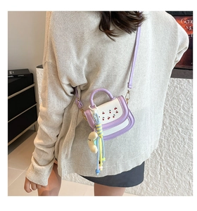Détail d'un mini sac bandoulière imprimé cerise avec poignée violette et charm peluche