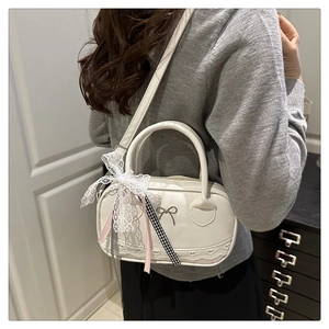 White faux leather bowling bag featuring lace bow details and a metal butterfly accent