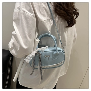Detail of light blue bowling bag with lace trim, ribbon, and metal bow accent