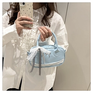 Close-up of light blue handbag with lace trim, checkered ribbon and silver bow detail