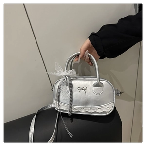 Detail of silver metallic bowling bag with lace heart trim and large white bow