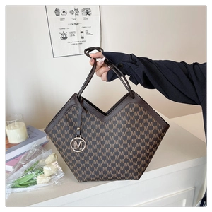 Detail of vintage brown tote bag featuring M-letter print and golden logo pendant