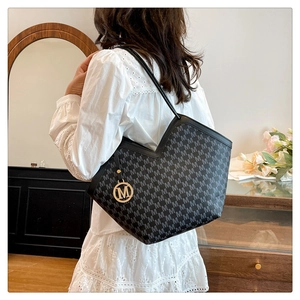 Detail view of the large capacity tote bag with letter print and golden M pendant