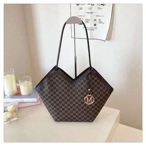 Detailed macro of brown vintage tote bag with M-pattern print and V-shaped opening