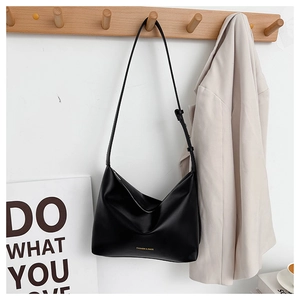 Detail of adjustable strap and gold brand lettering on black large capacity tote bag