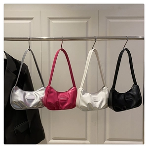 Detail shot of pleated underarm bags in silver, fuchsia, white, and black colors