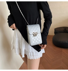 Dettaglio borsa porta cellulare trapuntata argento con fibbia a fiocco e catena sottile