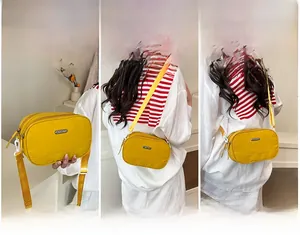 Yellow nylon crossbody bag with multiple zip compartments and versatile carrying styles