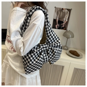 Detail of black and white gingham bow shoulder bag showing fabric texture and wide strap