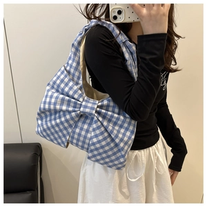 Détail du sac cabas en toile à carreaux bleu clair avec un grand nœud décoratif élégant