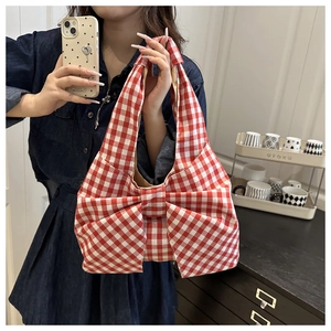 Gros plan du sac cabas en toile vichy rouge et blanc avec un grand nœud décoratif