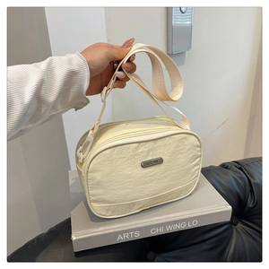 Detail of beige nylon crossbody bag with pleated texture and adjustable strap