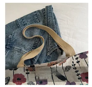 Close-up of floral tapestry tote bag with durable wide beige canvas handles and woven texture