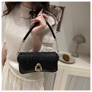 Détail du sac à bandoulière noir pailleté avec boucle fer à cheval dorée et chaîne