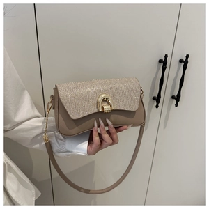 Détail du sac en cuir kaki avec paillettes et boucle en fer à cheval dorée