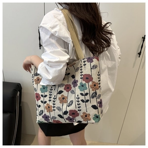 Detail of floral tapestry tote bag featuring colorful flower patterns and canvas straps