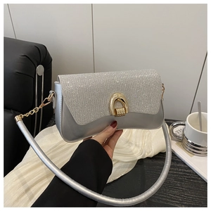 Détail du sac argenté à paillettes avec fermoir rotatif doré en U et bandoulière en chaîne
