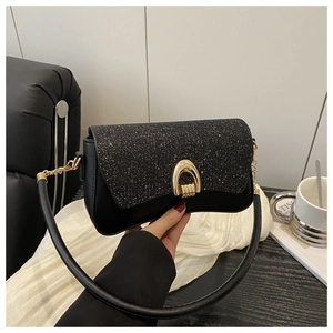 Détail du sac à bandoulière noir pailleté avec fermoir fer à cheval doré et bandoulière cuir
