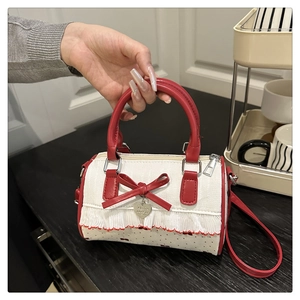Detail of red and white bow shoulder bag with silver heart pendant and floral ruffles