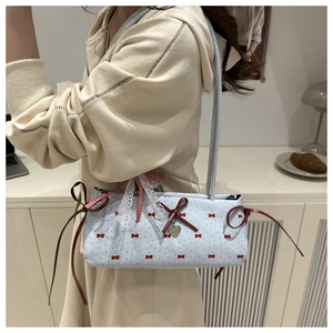 Close-up of sweet blue shoulder bag with red bow patterns and delicate lace trim detail