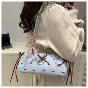 Detail of light blue bow baguette bag with lace ribbon and silver heart charm