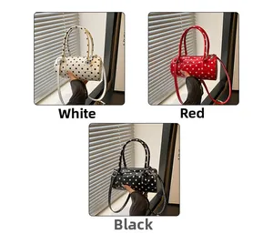Polka dot cylinder handbags shown in white, red and black with glossy patent finish