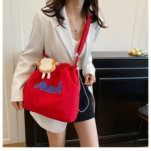 Detail of red drawstring canvas bag with Peach embroidery and cute toast plush charm