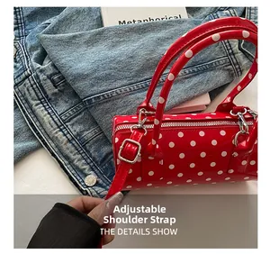 Detailed view of red polka dot cylinder bag with adjustable silver strap buckle