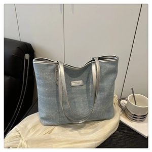 Detail of light blue denim tote bag with rhinestones and silver leather straps