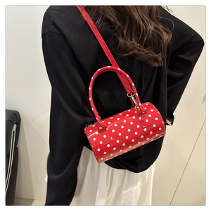 Detail of red and white polka dot mini Boston bag with glossy finish and silver hardware