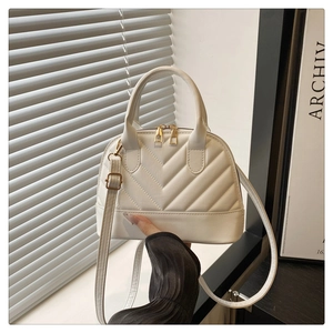 Detalle de bolso concha blanco acolchado en V con cremalleras dobles doradas de lujo