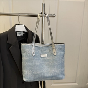 Light blue glitter tote bag with silver handles and rivet details for summer fashion