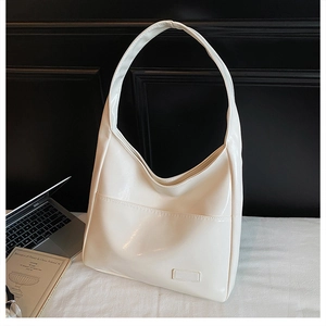 Detail of cream white faux leather tote bag with front pocket and glossy finish