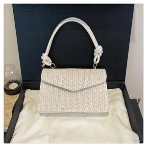 Sac à main en paille avec poignée en corde blanche sur velours dans une boîte cadeau