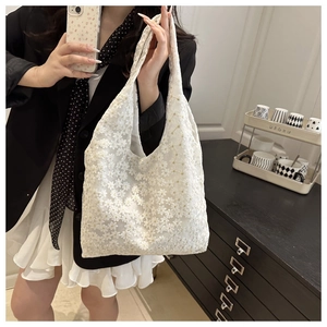 Detailed shot of white lace tote bag with 3D floral embroidery and mesh texture