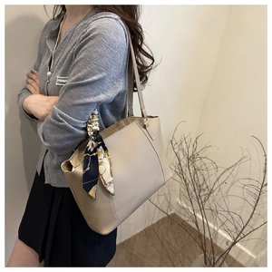 Detailed shot of beige tote bag handle with vintage printed silk scarf decoration