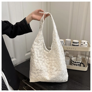 Detail of white daisy embroidery on delicate mesh tulle tote bag with a soft handle